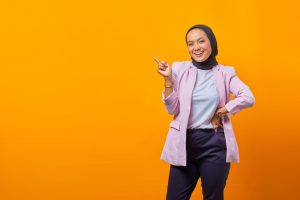 Portrait,Of,Cheerful,Attractive,Asian,Woman,Pointing,Finger,At,Empty